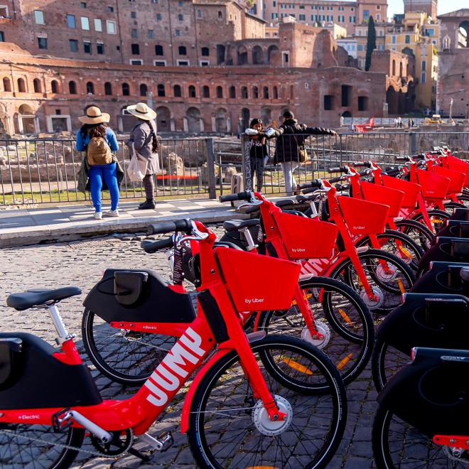 A row of affordable red electric bikes in Rome, Italy.