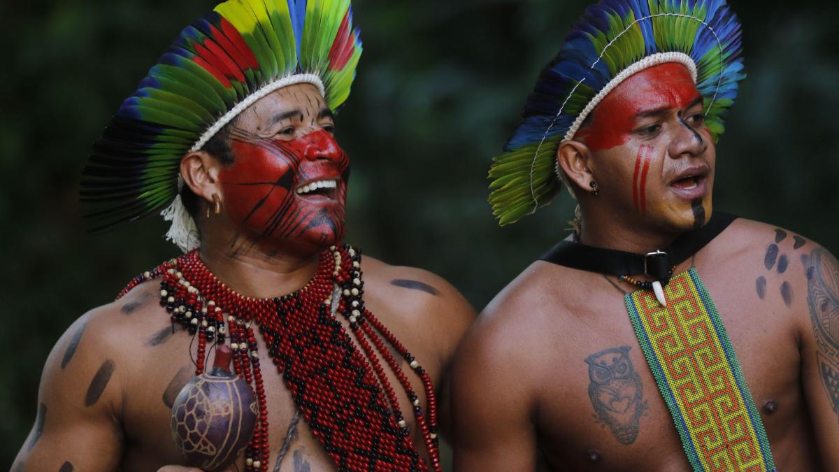 Brazilian indigenous men of Pataxó ethnic group celebrate International Day of Indigenous Peoples with traditional songs and dances in typical costume.