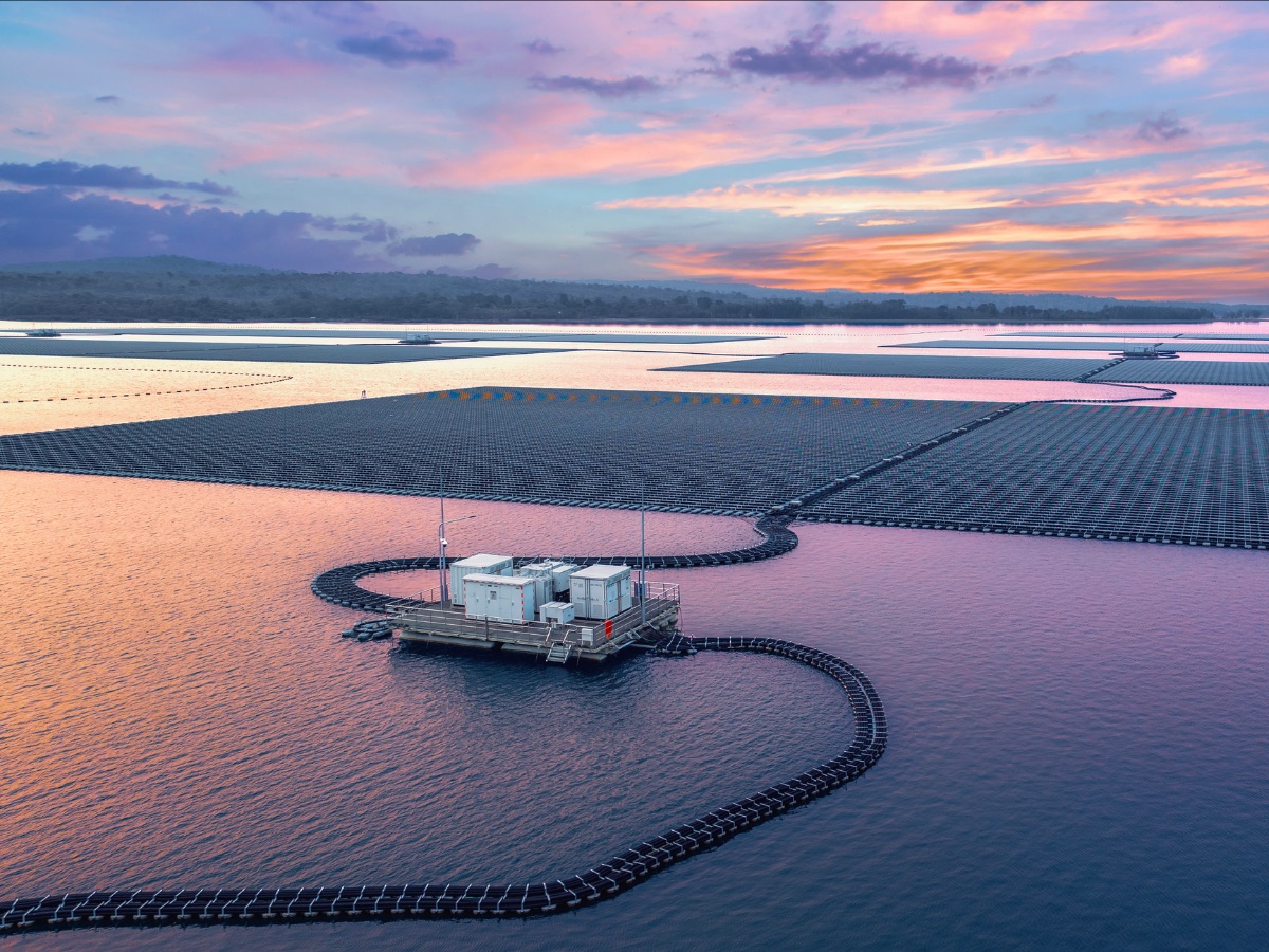 Aerial shot at sunset of hybrid floating solar cells at Sirindhorn Dam, Thailand.