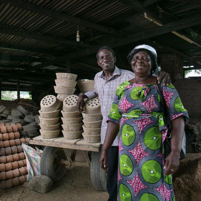 Richard and Gladys Eken standing beside ceramic liners that they make for clean cookstoves.