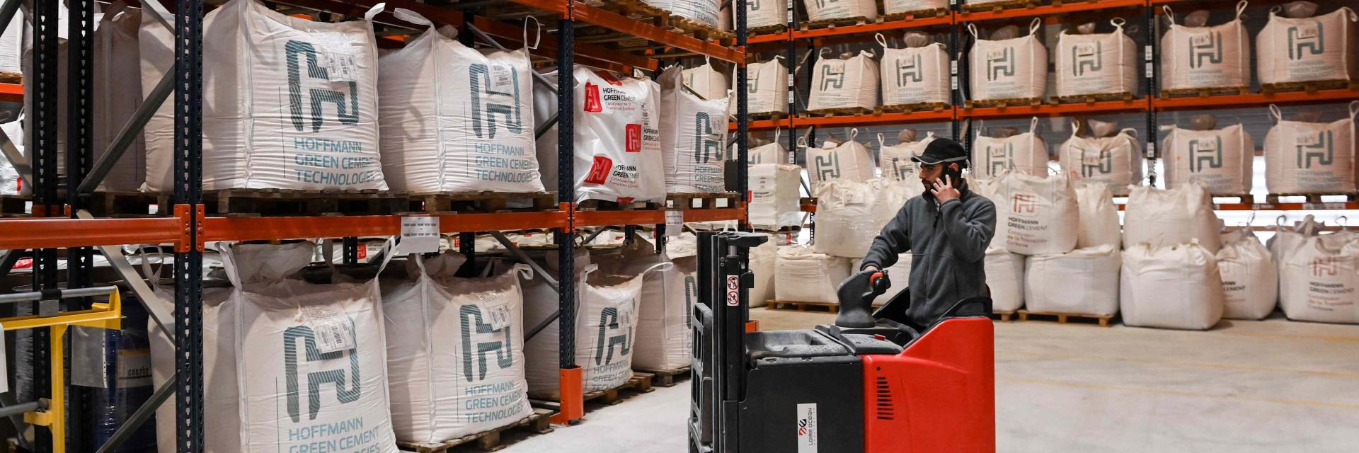 A Hoffmann Green Cement Technologies worker moves bags of cement with a forklift, in a storage room in the production site, in Bournezeau, western France.