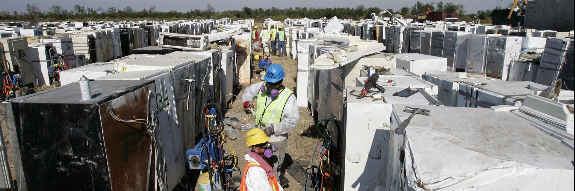 EPA workers prepare to remove freon, compressor oil, mercury switches, and rotten food from refrigerators and other "white goods" at the Katrina Dumpsite on October 19, 2005, in New Orleans, Louisiana.