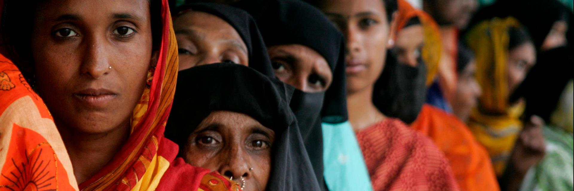 Bangladeshi villagers line up to have their photographs and signatures taken as part of a United Nations Development Programme (UNDP) voting initiative.